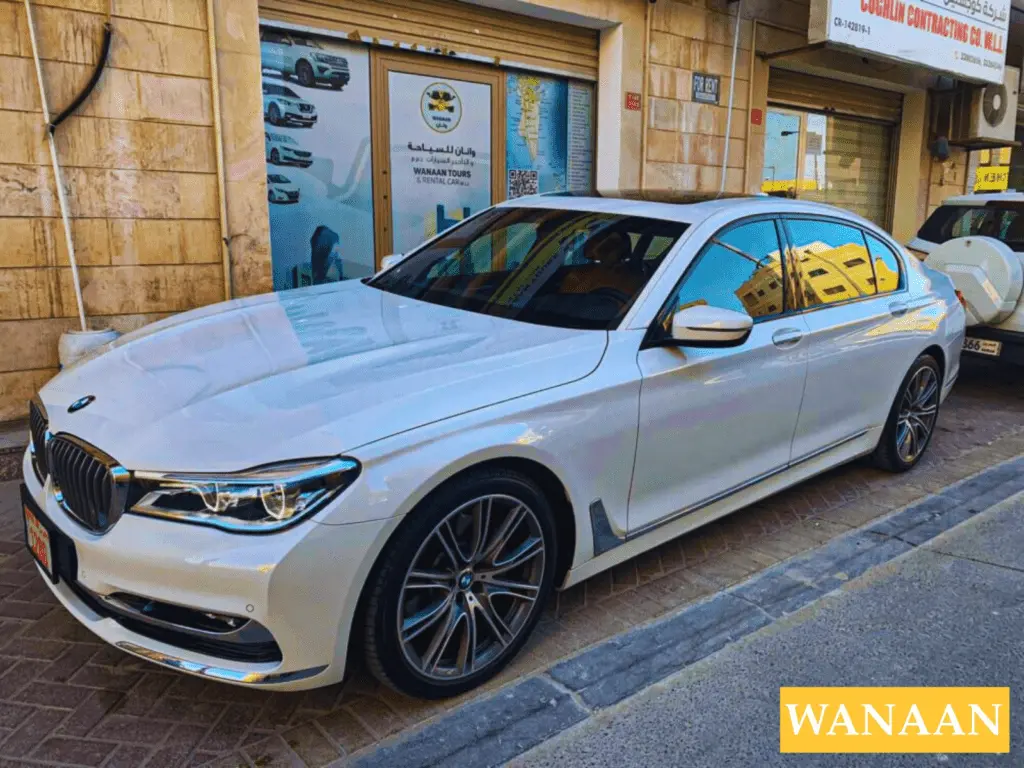 Find The Premier Choice for Car Rentals in Juffair & Manama With Us 3 White BMW 7 Series luxury sedan parked outside the Wanaan car rental office